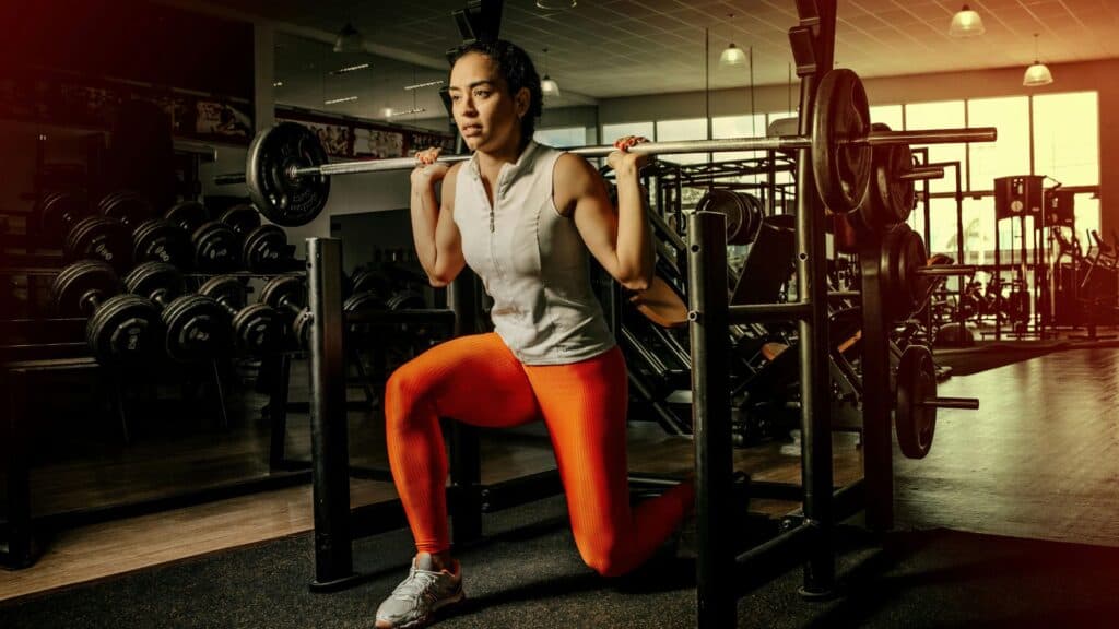 Mujer entrenando fuerza con barras para ganar masa muscular.